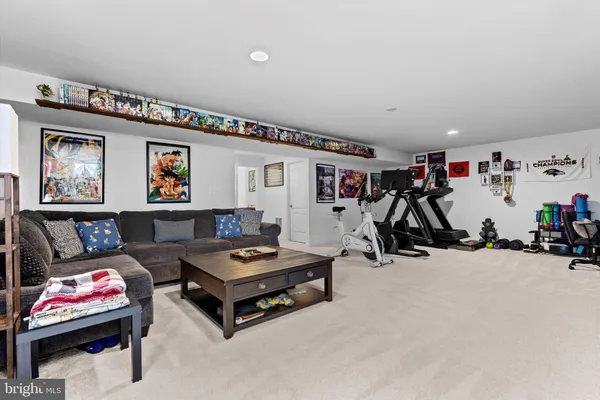 a living room with furniture a air conditioner and a flat screen tv