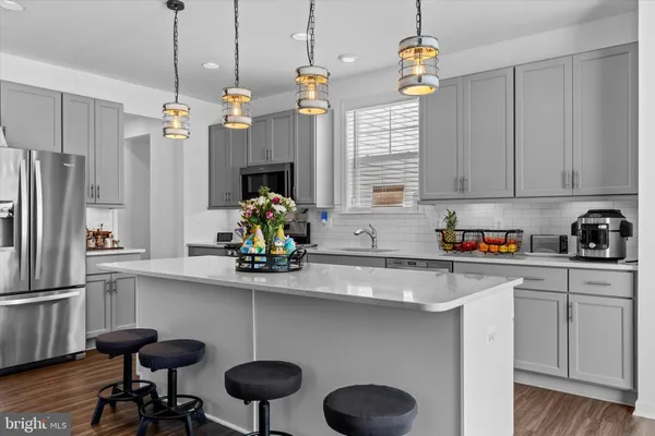 a kitchen with stainless steel appliances granite countertop a sink a stove and a refrigerator