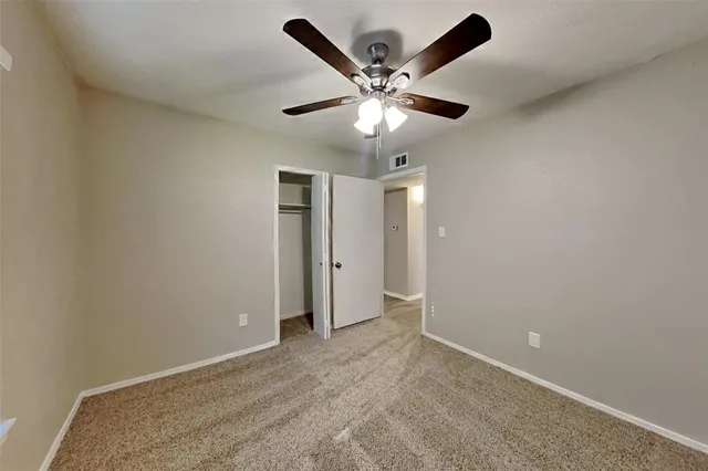 en empty room with window and ceiling fan
