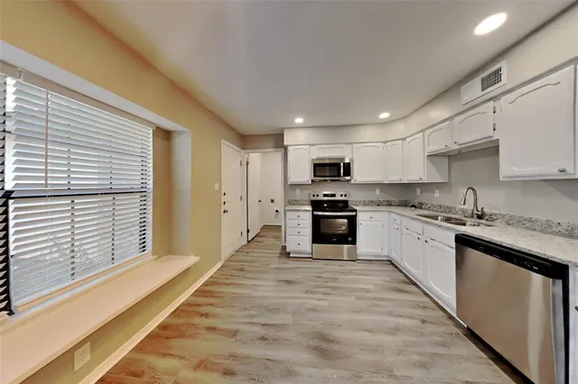 a large kitchen with kitchen island a sink stainless steel appliances and cabinets