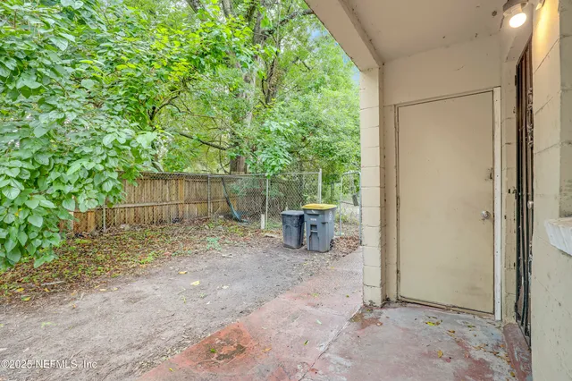 a view of a room with a tree and wooden fence