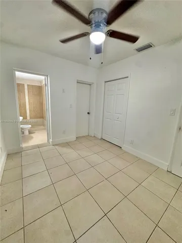 a view of an empty room and chandelier fan