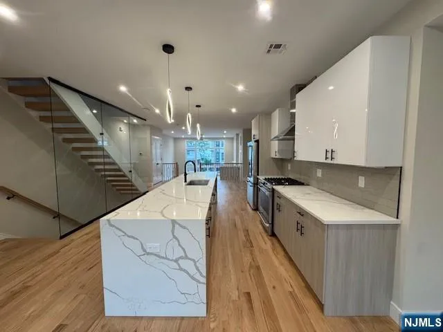 a large kitchen with stainless steel appliances a sink a counter top space cabinets and a counter top space