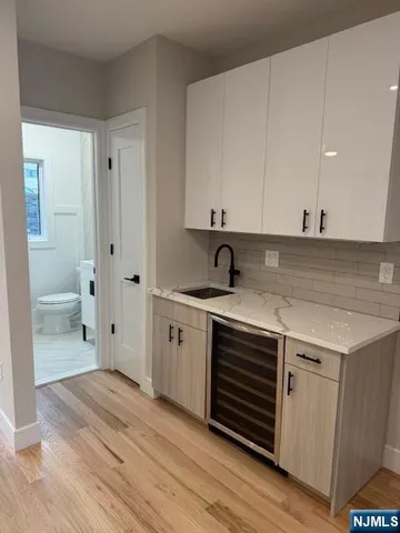 a view of a kitchen with white cabinets and wooden floor