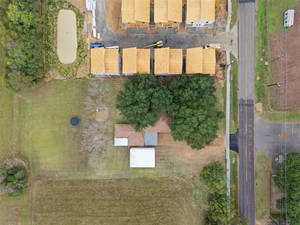 an aerial view of residential houses with outdoor space and ocean view