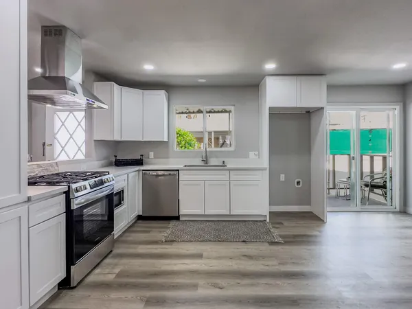 a kitchen with stainless steel appliances granite countertop a stove a sink and a refrigerator