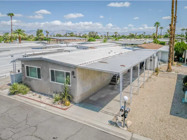 an aerial view of a house with a yard and seating space