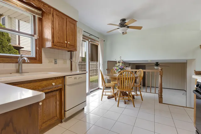 a kitchen with stainless steel appliances granite countertop a sink a stove a dining table and chairs