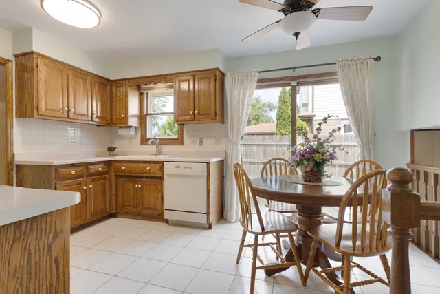a kitchen with a table chairs sink and cabinets