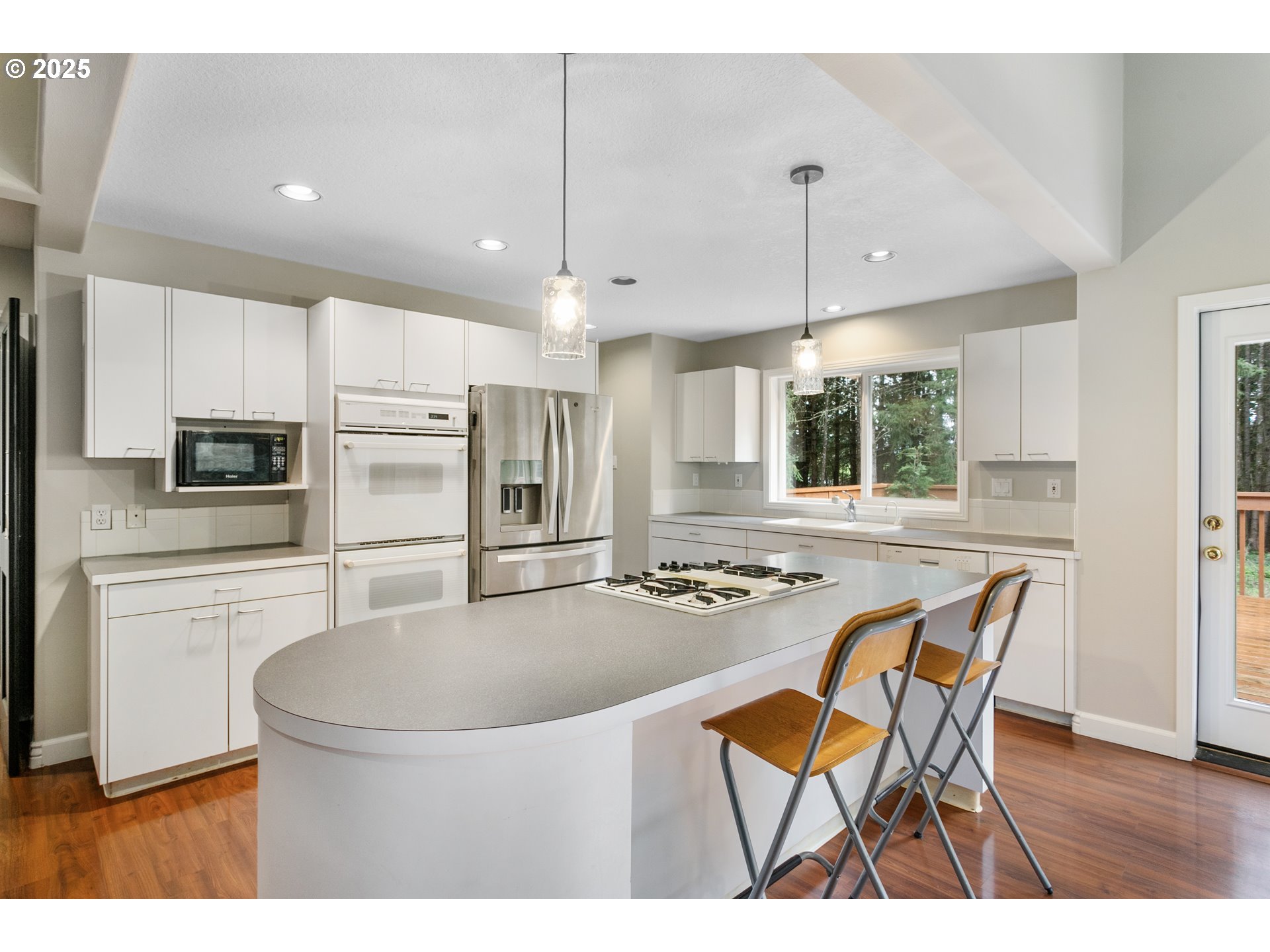 32370 Southeast Judd Road Eagle Creek, OR 97022 - Photo 18 of 48 a kitchen with stainless steel appliances kitchen island granite countertop a sink a stove a dining table and chairs