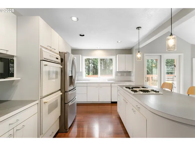 a kitchen with a refrigerator a sink and white cabinets