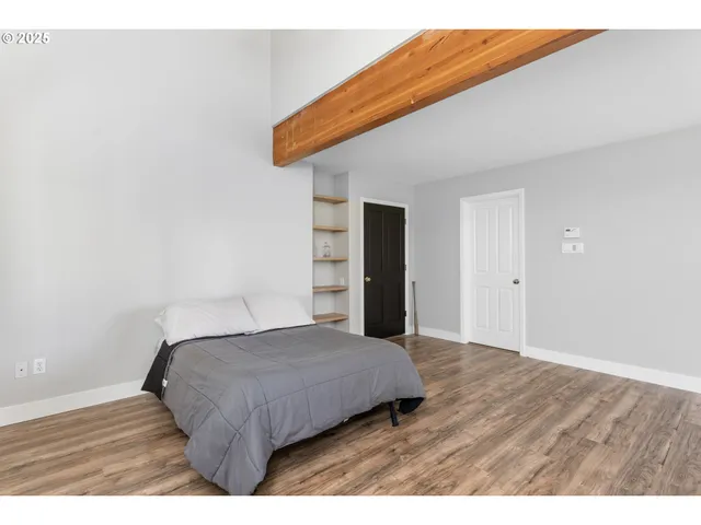 a bedroom with a bed and a flat tv screen on dresser