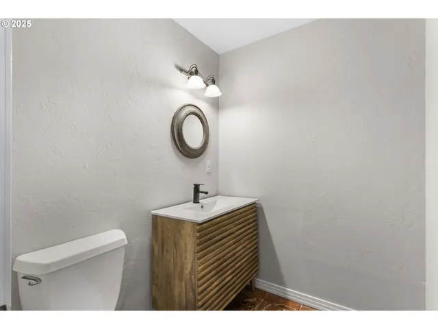 a bathroom with a sink a toilet and a mirror