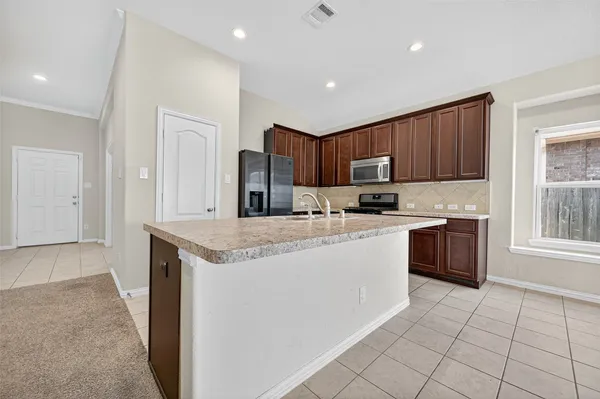 a kitchen with stainless steel appliances granite countertop a stove a sink and a refrigerator