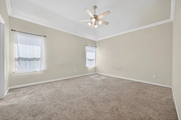 an empty room with windows and fan