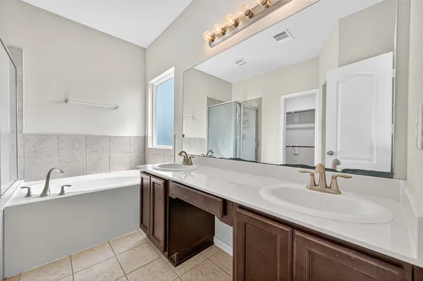 a bathroom with a sink double vanity granite tub and a mirror