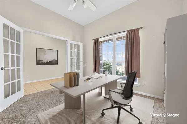 a view of a workspace with furniture and a window