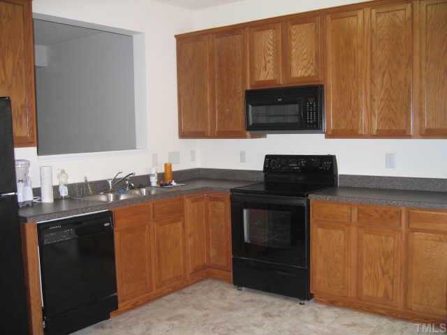 a kitchen with granite countertop a stove and a microwave