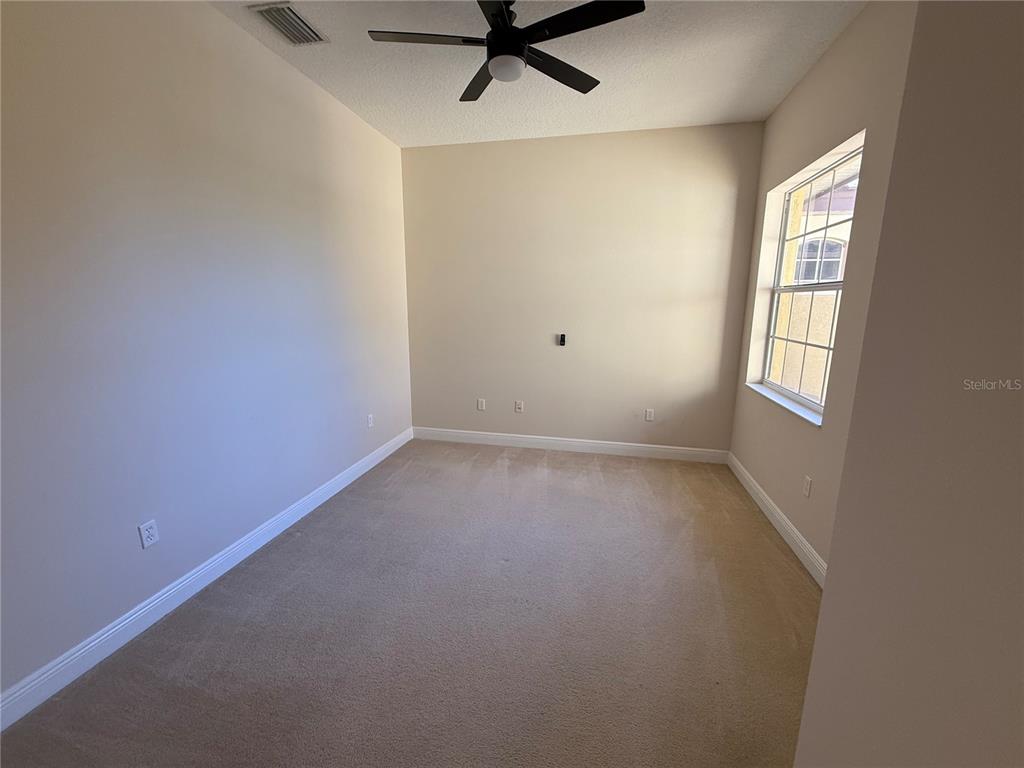 8153 Miramar Way Lakewood Ranch, FL 34202 - Photo 29 of 42 an empty room with a window and a ceiling fan