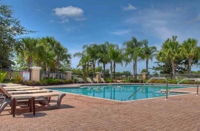 a view of a backyard with swimming pool and sitting area