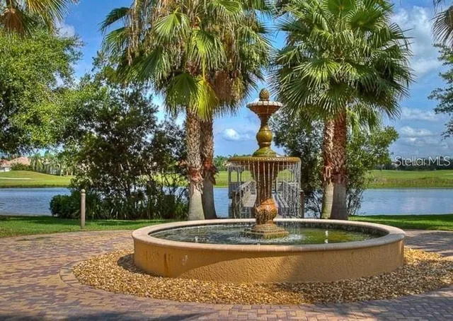 a view of a fountain in the yard with palm trees