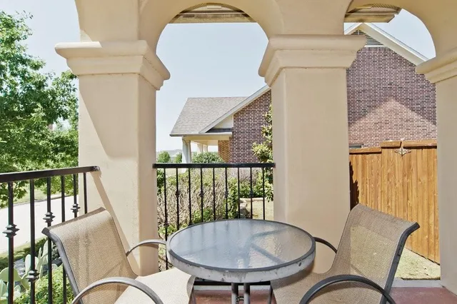 a balcony with table and chairs