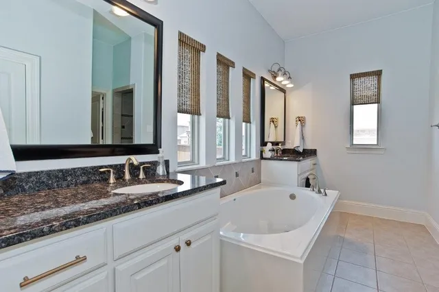 a bathroom with double vanity sinks and a bathtub