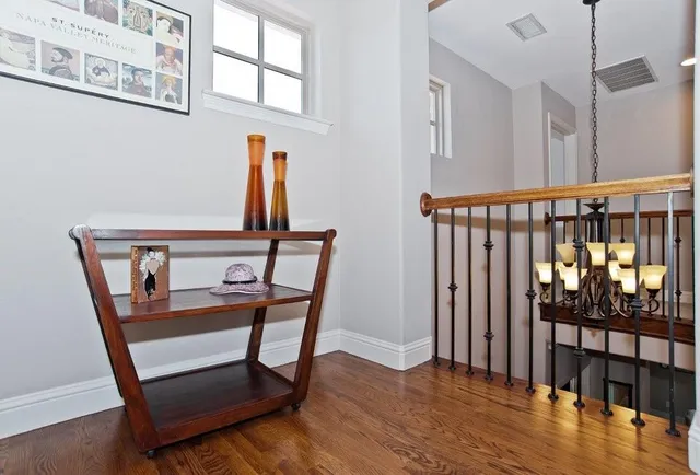 a view of a hallway with wooden floor and windows