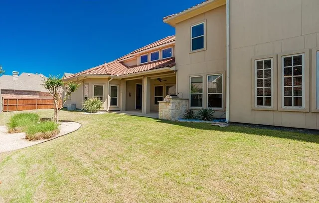 front view of house with a yard and potted plants