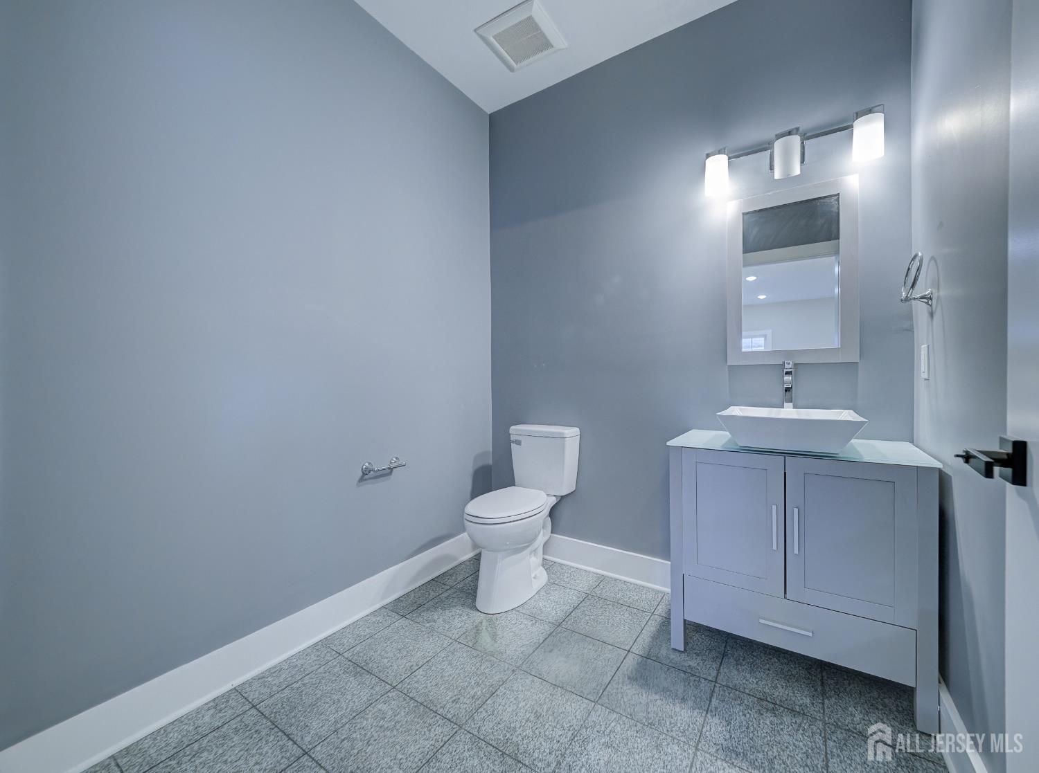 8 Travers Avenue, Unit 1 Edison, NJ 08817 - Photo 14 of 19 a bathroom with a toilet a sink and mirror