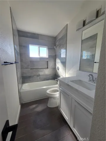 a bathroom with a granite countertop toilet a sink and bathtub