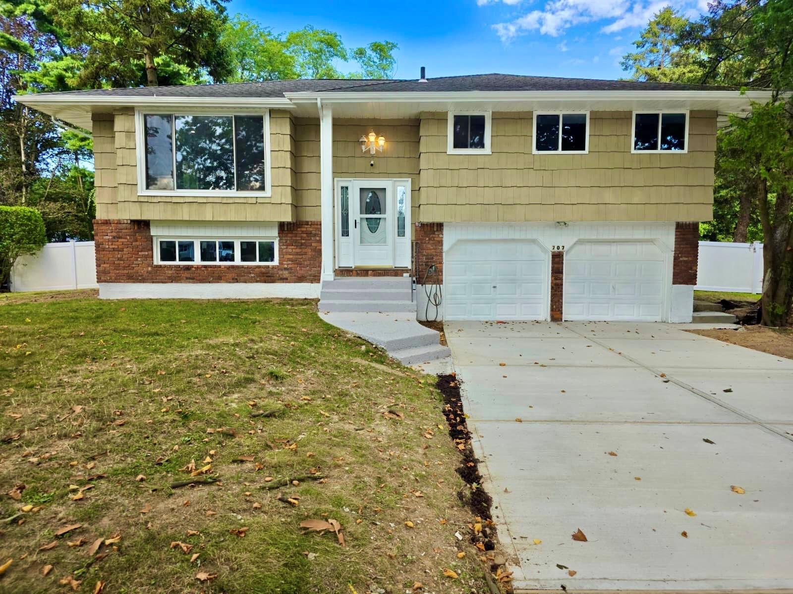 707 Larkfield Road Commack, NY 11725 - Photo 1 of 1 Split foyer home featuring brick siding, a garage, and driveway