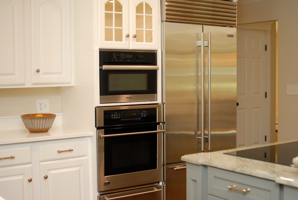 53 Sarah Way Concord, MA 01742 - Photo 12 of 42 a kitchen with a refrigerator and cabinets