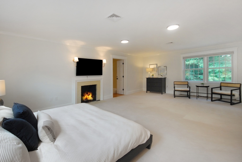 53 Sarah Way Concord, MA 01742 - Photo 21 of 42 a bed room with a bed and a fireplace