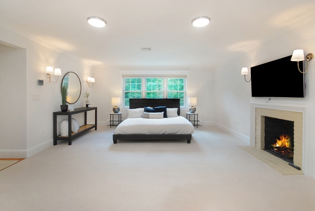 53 Sarah Way Concord, MA 01742 - Photo 22 of 42 a bed room with a bed and a fireplace