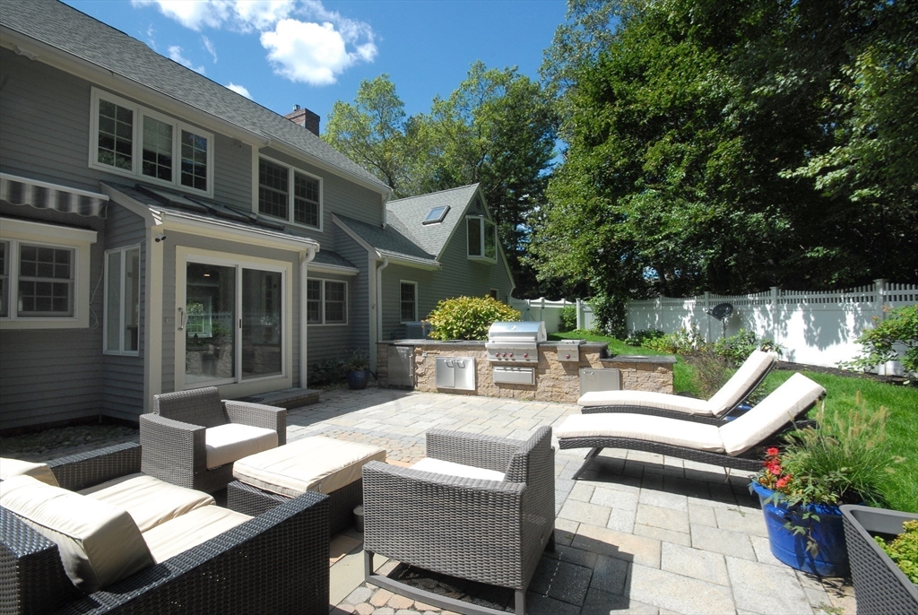 53 Sarah Way Concord, MA 01742 - Photo 39 of 42 a view of a patio with couches chairs potted plants and a large tree