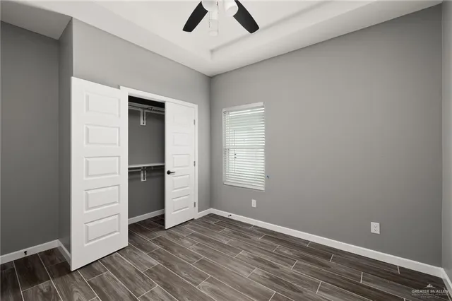 an empty room with closet and windows