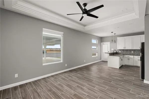 a view of a kitchen with wooden floor and a window