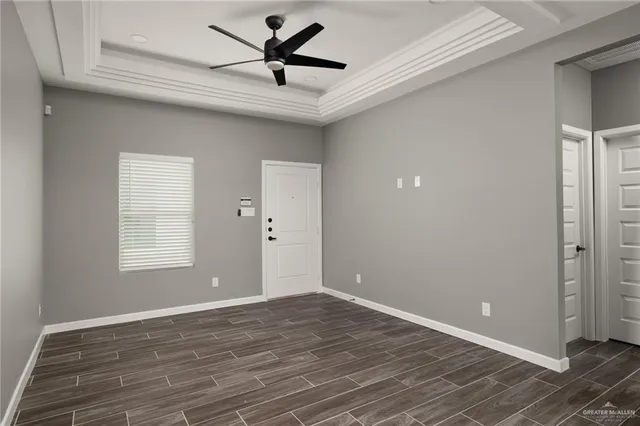 a view of a big room with wooden floor and windows
