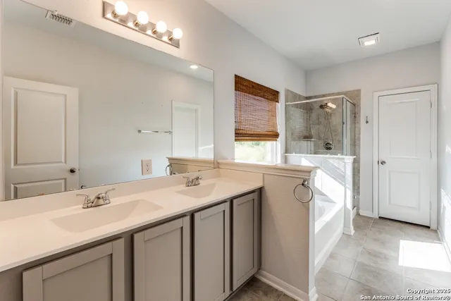 a spacious bathroom with a double vanity sink a mirror and a shower