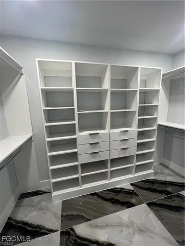 a view of walk in closet with empty racks
