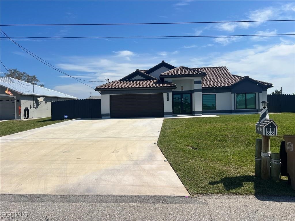 1215 Northwest 38th Avenue Cape Coral, FL 33993 - Photo 2 of 35 a front view of a house with a garden