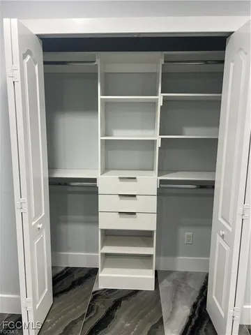 a view of walk in closet with empty racks