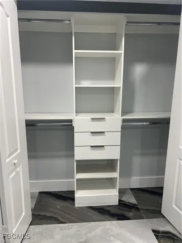 a view of walk in closet with empty racks