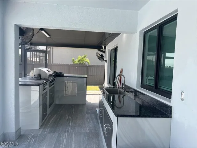 a kitchen with stainless steel appliances granite countertop a sink a stove and a refrigerator