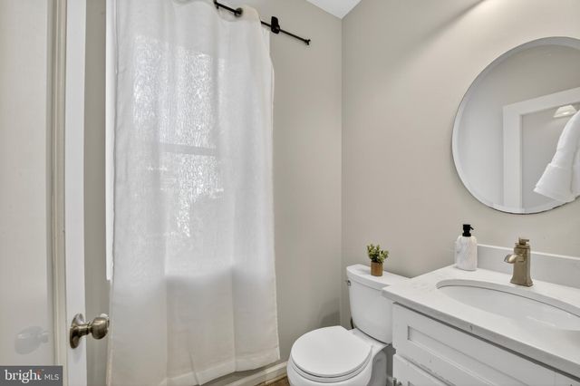 a bathroom with a granite countertop sink mirror vanity and toilet