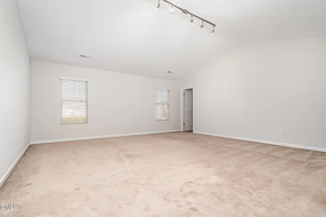 a view of a white house with a big yard and large trees