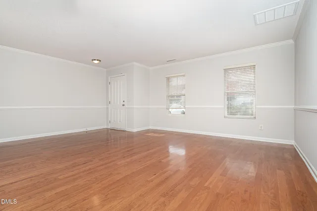 a kitchen with stainless steel appliances a refrigerator a sink dishwasher a oven with white cabinets and wooden floor