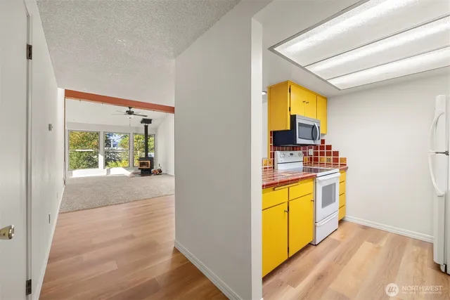 a view of hallway with wooden floor and a fireplace
