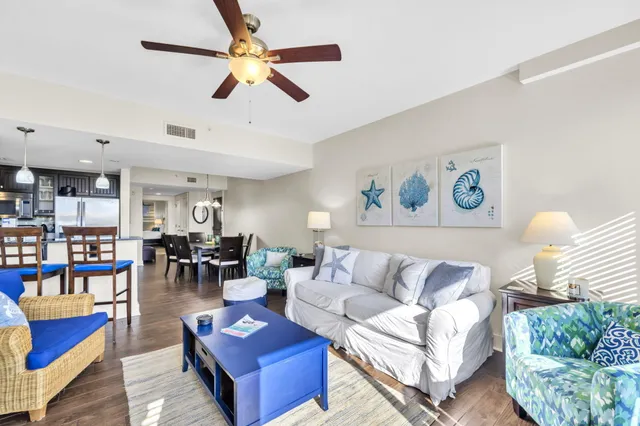 a living room with furniture kitchen view and a window